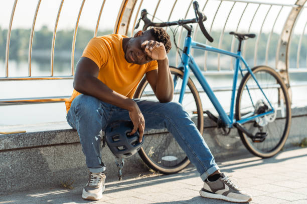 Tired african american man looking away while relaxing after bicycle riding