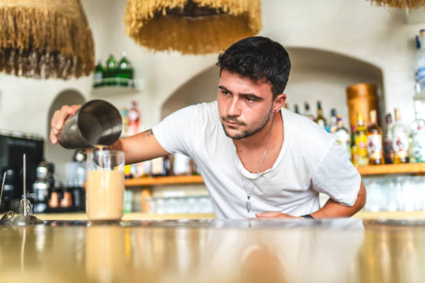 istock Male bartender pours drink into glass 1663658914