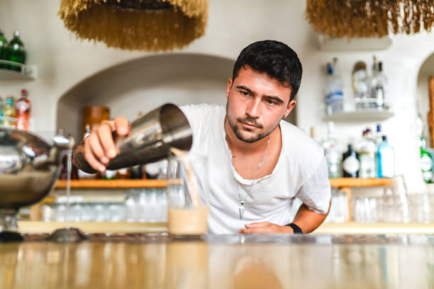 istock Male bartender pours drink into glass 1663659435