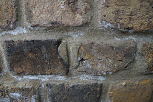 istock Brick wall background texture close up. Dirty brick wall with peeling plaster 1663681718