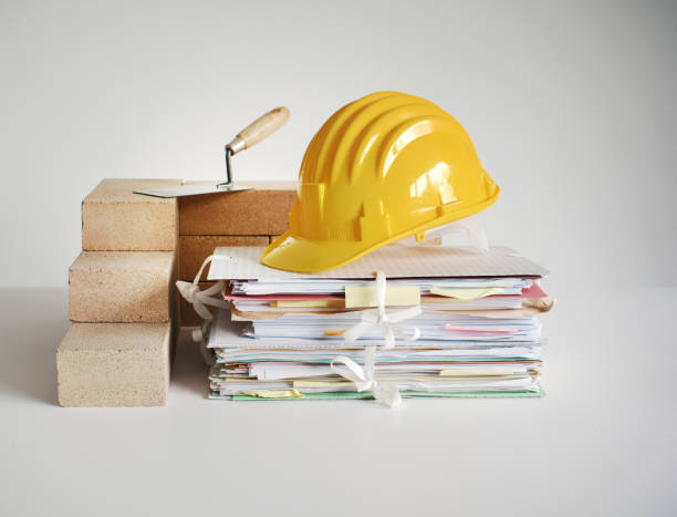 Bricks, work tools and pile of paperwork: designing and building a house