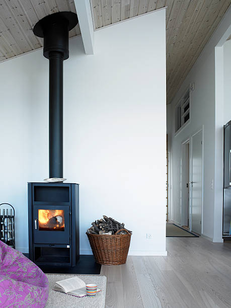 Clean home with wood stove In the light room the wood stove is placed with a fluffy carpet in front, where you can sit down and enjoy the cosiness with a book in the illumination of the flames. wood burning stove stock pictures, royalty-free photos & images
