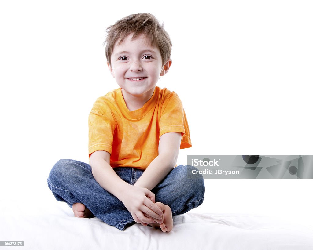 Real People:  Smiling Caucasian Little Boy Sitting Cross Legged A full length image of a smiling caucasian little real boy sitting cross legged with his hands clasped in front of him. Child Stock Photo