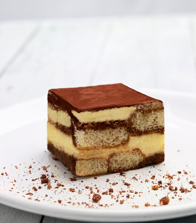 An Italian specialty -Tiramisu coffee cake.Here served on a white plate with a sprinkle of honey roasted crumbs.