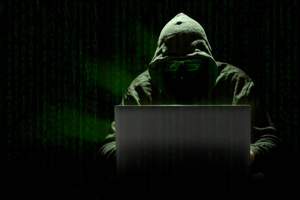 istock A hooded hacker committing a cyber attack with a laptop, against a background of matrix-style computer code. Concept of computer crimes in the digital age 1663736682