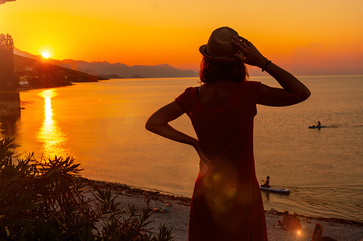 Silhouette of a woman at sunset at Shkoder lake in Shiroka municipality, summer vacation. Albania