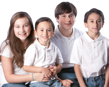 A waist up image of a caucasian family with siblings - one sister and three brothers.