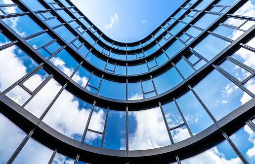 Modern style hi rise blue glass building exterior with sunny blue sky background 3d render for future business headquarter digital smart city concept