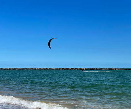 Man kitesurfer ready for kite surfing rides in blue sea