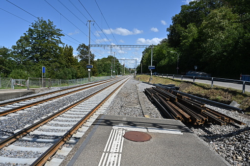 The tracks which leading to the railway station in village Urdorf in Switzerland with some spare rails and pipes aside during reconstruction.