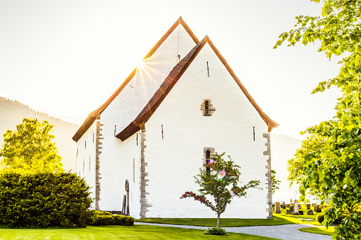 a staircase leads to the church built entirely of wood with tree and shrub in the foreground