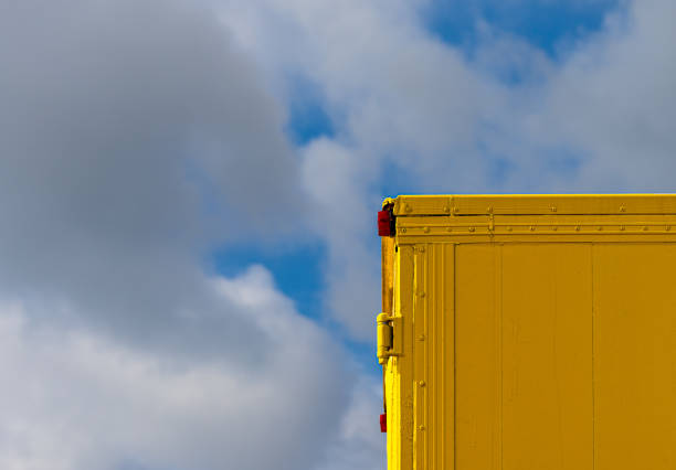 istock Yellow corner of cargo container against sky 1663794286