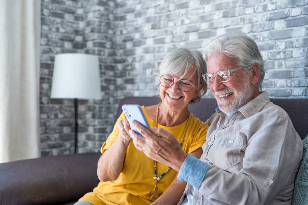 istock Elderly grandfather and grandmother spend time having fun using smartphone apps, middle-aged wife enjoy online entertainments, taking selfie with old husband, older generation and modern tech concept 1663798820