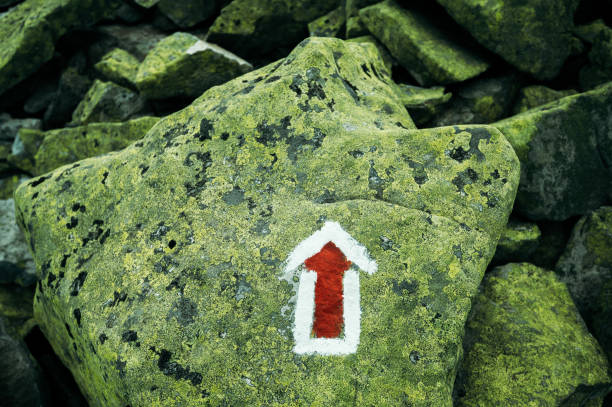 Mountain path arrow direction track sign on the stone symbol