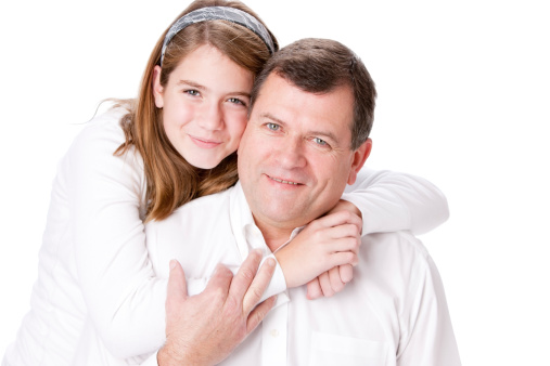 A head and shoulders image of a caucasian father and daughter. The daughter is hugging her father. 