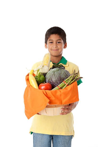 gesunde ernährung: hispanische jungen hält korb mit gemüse taille - child vegetable squash corn stock-fotos und bilder