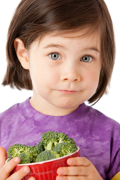 gesunde ernährung: europäischer abstammung kleines mädchen mit brokkoli gemüse kopf und schultern - child portrait fine art portrait multi colored stock-fotos und bilder