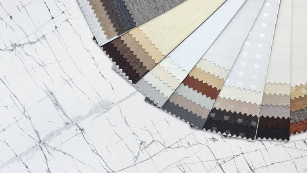 istock swatch of blackout drapery fabric samples with different textures in earth color tone, close up view, placed on white carrara marble table with blank space for design. 1663828760