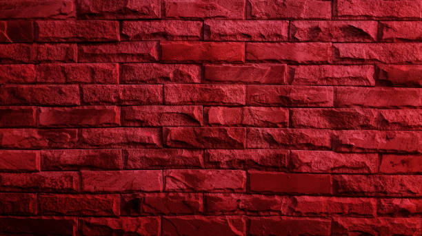 istock aged red brick stone wall , close up view, used as background with blank space for design. bright red color of abstract style design decorative uneven cracked real stone wall surface. 1663829813