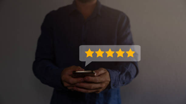 istock close up Man hand using smartphone with popup five star icon for feedback review satisfaction service, Customer service experience and business satisfaction survey. 1663834208