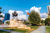 Skanderbeg horse monument at Skanderbeg Square in Tirana and the red flag of Albania
