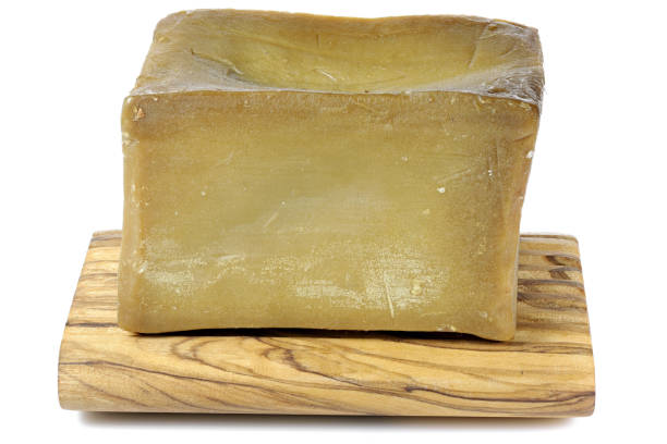 olive oil based hand-cut soap on underlay made of olive wood isolated on white background