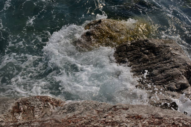 istock Sea wave splash on rocky beach. Ocean waves breaking on rocks. 1663887022
