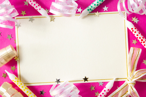 A blank card with birthday candles, ribbons and stars on a bright pink background, with copy space.  
Party/ Celebration background.