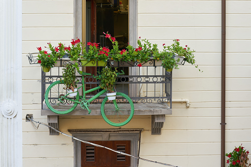 green bicycle with plants as decoration on a balcony in the old town of Malcesine in Italy