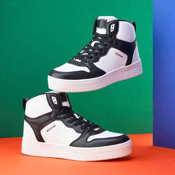 istock Classic Casual shoes into Creative minimal design. Unbranded sneaker or trainer on orange, blue, green background. Fashion store or magazine concept. Pair of sport shoes. 1663937652