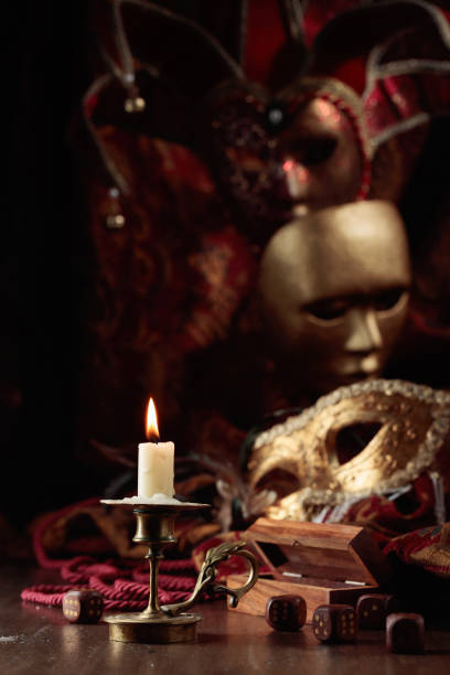 Burning candle, dice, and carnival masks.