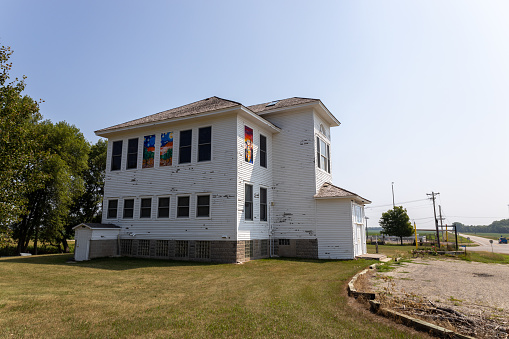 Willmar, Minnesota, USA - July 24, 2023: Landscape view of the Svea School, a four-floor country schoolhouse with Neoclassical architecture, that was built in 1907, and listed in the National Register of Historic Places. After being abandoned for some years, it is currently being restored and used as an art education studio by the non-profit corporation DEMO.