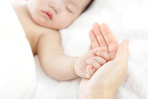 pequeno bebê com a mãe de mãos - sheet human hand bed women - fotografias e filmes do acervo