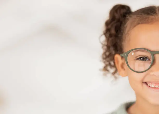 Photo of Mockup, advertising and girl with glasses from optometrist for vision in eyes at a clinic, store or shop. Half, happy and child with medical eyeglasses from optician with mock up space for marketing