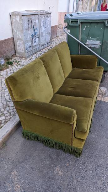 istock An old fabric sofa stands near a trash can next to the sidewalk 1663984522