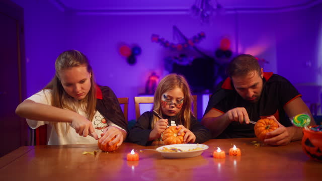 Young family making Halloween decorations