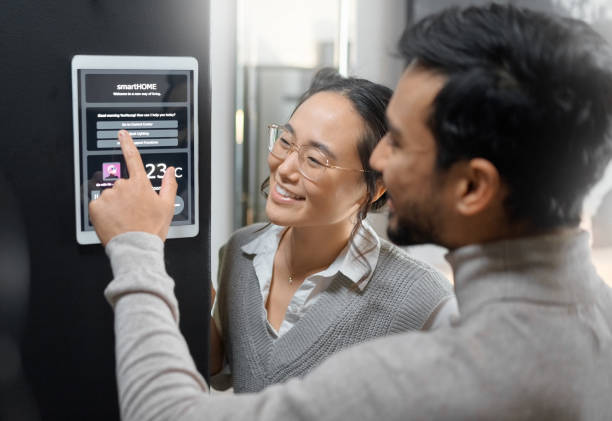 istock Smart home technology, wall system and couple with digital screen for room lighting, safety security network or house automation. AI software app, ui control panel and Asian people with IOT dashboard 1663999468