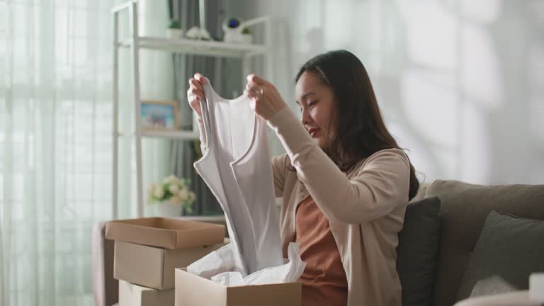 Asian woman received cardboard box for online shopping store and delivery to home