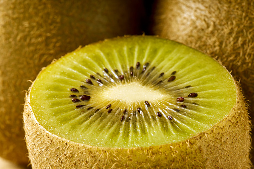 several whole and half ripe and sweet kiwi fruits