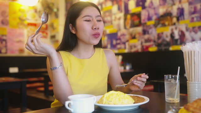 Asian woman travels eating curry fried cutlet pork on rice