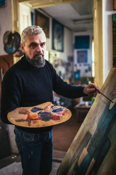 istock Mature man painting on canvas in art studio. 1664043919