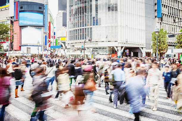 Crowded Pedestrians Shibuya Crossing Tokyo People walking over the famous zebra crossing at Shibuya Crossing in Downtown Tokyo. Motion Blurred People. Tokyo, Japan. tokyo crowds on the famous shibuya crossing japan stock pictures, royalty-free photos & images