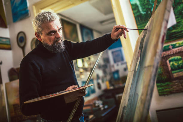 istock Mature man painting on canvas in art studio. 1664047858