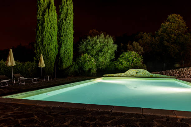 istock Illuminated swimming pool on the Montemassi hillside surrounded by cypresses and oleanders. Italy 1664056272