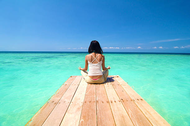 istock asian girl performing beach yoga 166406558