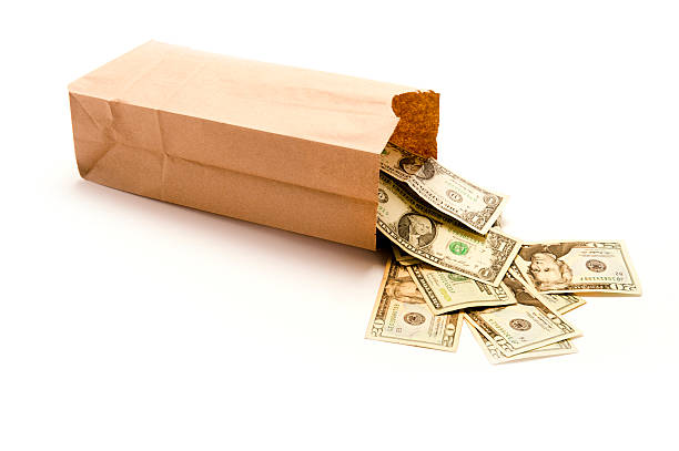 Bag of money spilling out stock photo