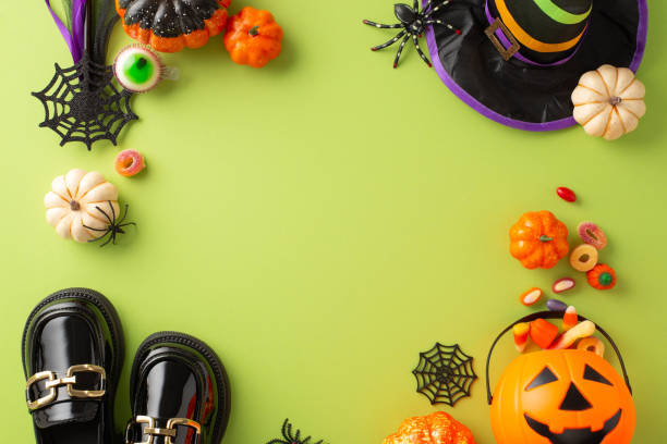 istock Playful kids' Halloween celebration scene. Overhead view image presenting candies, youngster's costume items and Halloween-themed decorations on isolated green backdrop, offering space for ad or text 1664068119