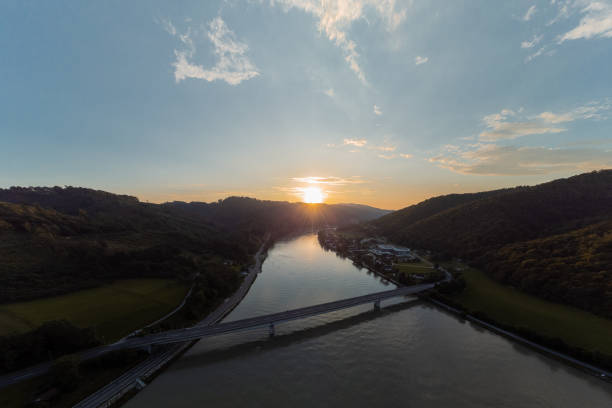 istock Bridge over Danube or Donau river just after entering austria. Big bridge over the wide river just at sunset, sun setting down behind the hills. 1664068649