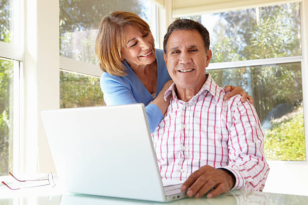 istock Senior Hispanic Couple In Home Office With Laptop 166407462