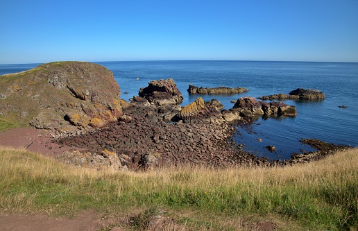 Scottish coastline with cliff and rocks on the beach in St.Abb's Head,  National Nature Reserve,  southeastern coast of Scotland